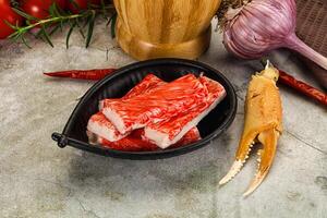 A bowl of raw crab meat with a knife and a bottle of wine photo