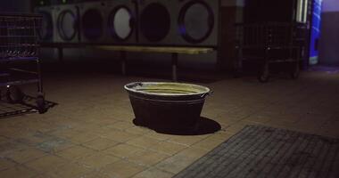 CGI Old black basin sits alone in an empty laundromat at night video