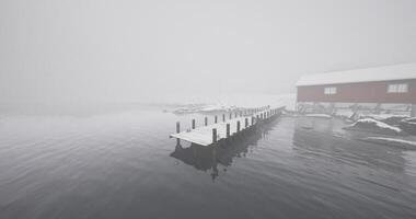 CGI Tranquil winter morning at a foggy lakeside dock with a cozy cabin video