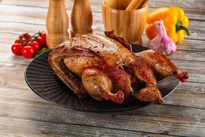 A roasted chicken on a plate with spices and other ingredients photo