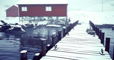 CGI Snow covered dock with a red cabin near calm water during winter video