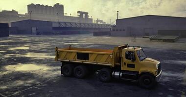 CGI Yellow dump truck parked at an industrial site during cloudy weather video