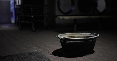 CGI Dark laundry room with a metal basin resting on the floor video