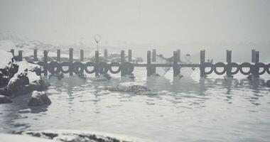 CGI Snowy lakefront with a wooden dock and winter landscape under foggy skies video