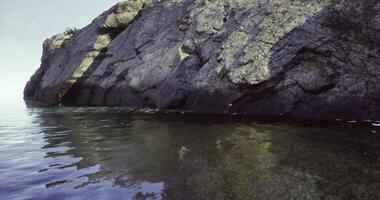 CGI Calm waters reflect rocky cliffs at serene coastal location during twilight video