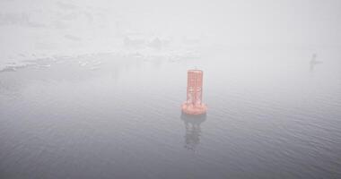 CGI Misty morning on the water with an orange buoy surrounded by fog video