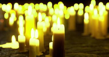 CGI Light from numerous candles creates a warm atmosphere during a nighttime vigil video