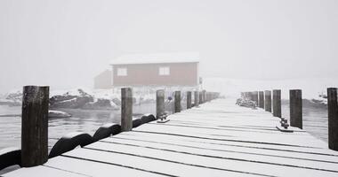 CGI Snowy pier extends into foggy waters near a red cabin in winter video