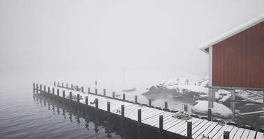 CGI Snow covered dock near a red cabin in a foggy winter landscape video