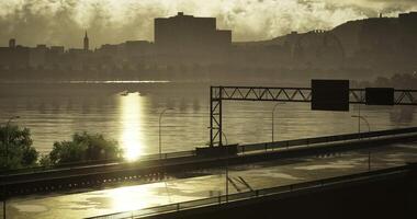 CGI Early morning light reflects on the water alongside a quiet roadway video