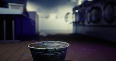 CGI Rusty bucket placed on floor in dimly lit laundromat at night video