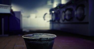 CGI Bucket placed on the floor in a laundromat with washing machines in background video