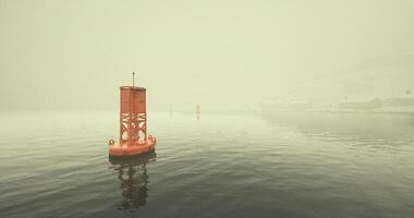 CGI Foggy morning with an orange buoy navigating calm waters in a harbor video
