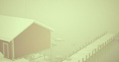 CGI Fog envelops a red cabin and dock on a winter morning by a lake video