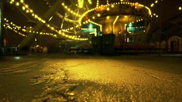 CGI Nighttime carnival lights reflect on wet pavement near a carousel video