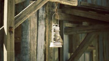 CGI Vintage lantern hanging from wooden structure in a rustic setting video