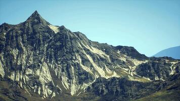 CGI Majestic mountain peak with rugged terrain under clear blue sky at midday video
