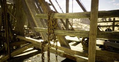 CGI Rusty chains hang on an old wooden structure in a remote canyon during daylight video