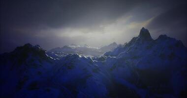 CGI Majestic snow covered mountains under a moody sky at twilight video