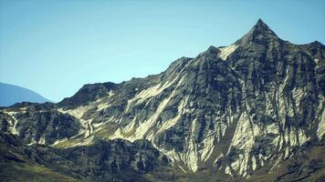 CGI Majestic mountain peak rises against clear blue sky in sunny setting video