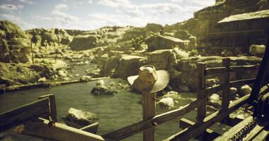 CGI Rustic cowboy hat resting on wooden fence near serene river in canyon video
