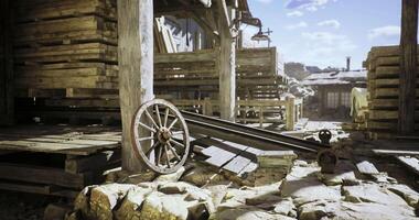 CGI Old wooden structures and wagon wheel in a deserted settlement during day video