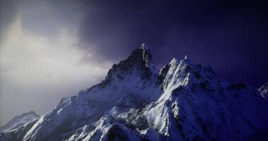 CGI Majestic snow capped mountain peak under dramatic sky at twilight video