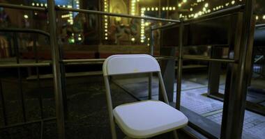 CGI Empty chair placed in front of a vibrant carnival backdrop at night video