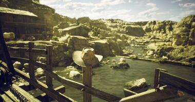 CGI Cowboy hat rests on fence overlooking serene river landscape in rustic setting video