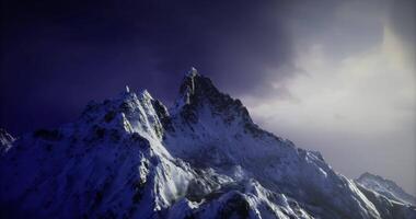 CGI Majestic snow covered mountain peaks under a dramatic twilight sky video