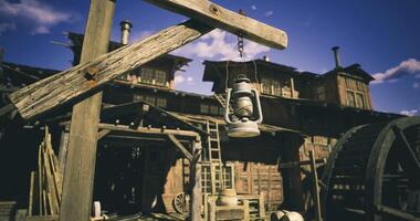 CGI Old lantern hanging in front of rustic wooden buildings under blue sky video