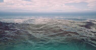 CGI Soft waves rolling gently under a pastel sky at a tranquil ocean video