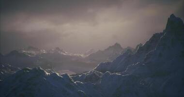 CGI Majestic snow covered mountains under a dramatic sky at twilight video