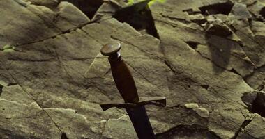 CGI Historic sword resting on ancient stone with moss and lichen in natural setting video