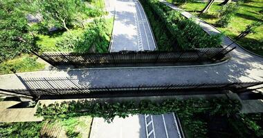 CGI Pedestrian walkway bridge crosses a quiet path in a park setting video