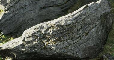 CGI Large natural rock formation highlighting unique textures in a grassy area video
