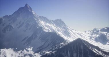 CGI Snowy mountain peaks rise majestically under a clear blue sky in high altitude video