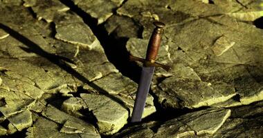 CGI Sword embedded in rocky ground at dusk suggesting a mythical quest video
