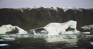 CGI Icebergs floating near rugged mountains on a clear day in the Arctic region video