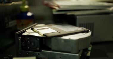 CGI Old technology revival in a workspace showcasing a hard drive and floppy disk video