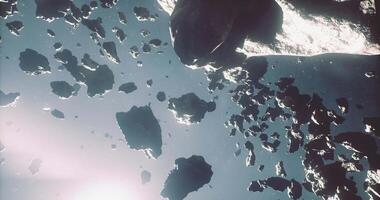 CGI Asteroids drifting through the vastness of space with glowing light effects video