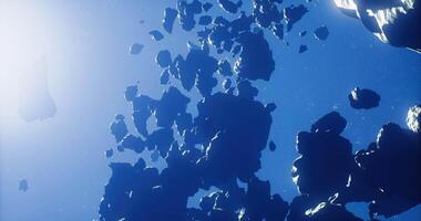 CGI Asteroids drifting in space illuminated by distant sunlight video