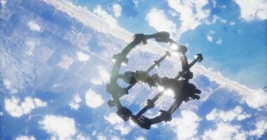 CGI Space station orbits Earth above cloud covered coast during daylight video