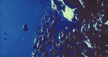 CGI Asteroids drifting in deep space under a vivid blue background video