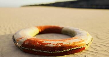 CGI Lifebuoy resting on sandy beach at sunset near calming waves video