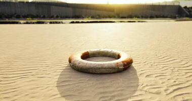 CGI Lifebuoy resting on sandy shore during golden hour by water video