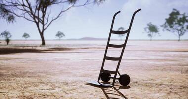 CGI Hand truck stands alone in barren landscape during bright daylight hours video