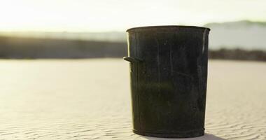 CGI Trash bin sits on sandy beach at sunset with gentle waves in background video