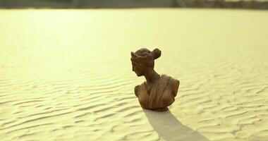 CGI Statue of a woman standing on textured sand under soft light during sunset video
