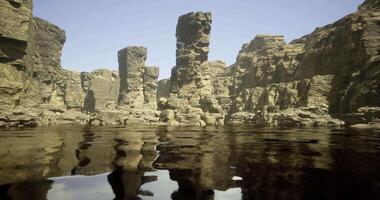 CGI Unique rock formations reflected in calm water during clear weather video